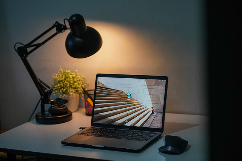 Schreibtischlampe leuchtet im Hintergrund eines Laptops